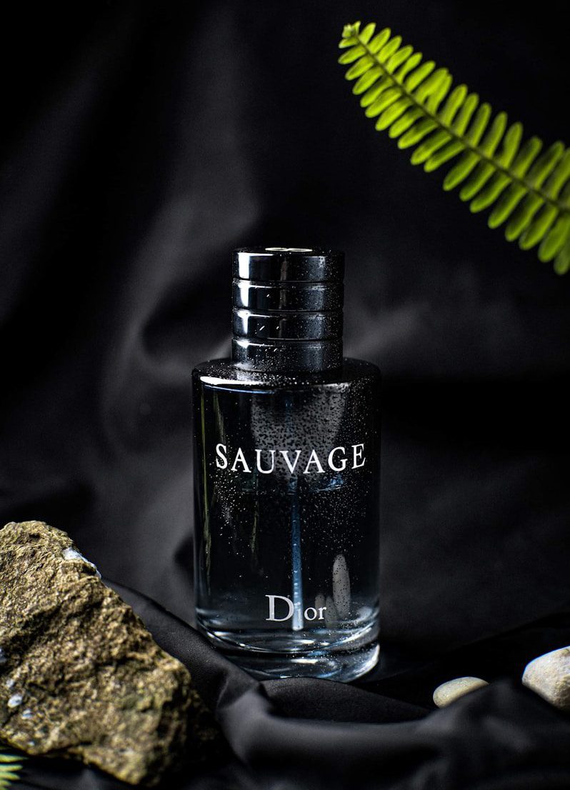 a bottle of cologne sitting next to a rock